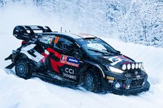 a rally car driving through the snow with its skis on it's back