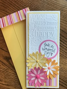 a card with flowers on it sitting next to an envelope that says, happy birthday