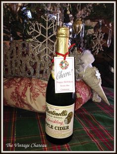 a bottle of wine sitting on top of a table next to a christmas tree with snowflakes