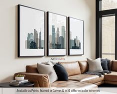 a living room with couches and pictures hanging on the wall above them in front of a window