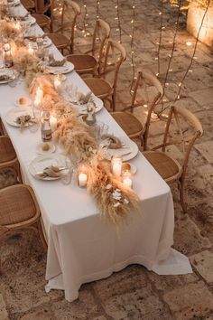 a long table with candles and plates on it