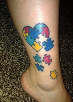 a foot with a puzzle piece tattoo on it