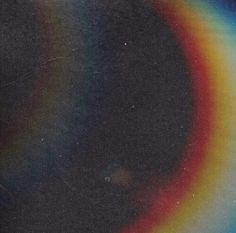 a rainbow colored object in the dark sky