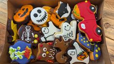 a box filled with halloween decorated cookies on top of a wooden table