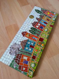 a close up of a colorful mosaic tile on a wooden floor