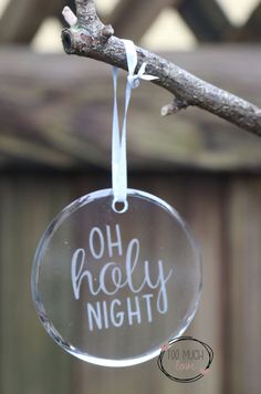 a glass ornament with the words oh holly night hanging from a tree branch