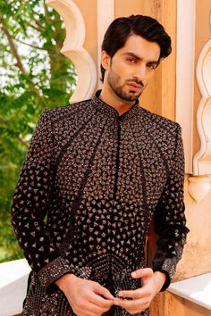 "Make an edgy statement with our ROYAL BLACK SHRUG INDO WESTERN designed thoughtfully for the modern Indian man. A fusion staple fit for every occasion, adds the right amount of cultural twist to the western silhouette. Color: Black Neck: Mandarin Collar Fabric: Saphire Fabric Embroidery: Kashmiri Embroidery Garment Type: Shrug Indo Western The Product Price is inclusive of: 1 Upper Indo-Western, 1 Sleeve-less Inner Indo-Western and 1 Trouser Style Bottom Model is 6'2\" wearing Size 38 Product color may slightly vary due to photographic lighting sources or your screen settings." Festive Black Semi-stitched Bandhgala, Formal Black Lehenga For Festivals, Black Lehenga For Formal Festivals, Traditional Black Sherwani For Party, Black Sherwani For Party And Festivals, Black Sherwani With Dabka Work For Party, Black Traditional Drape Sherwani For Party, Black Sherwani For Diwali Party, Black Sherwani For Party With Traditional Drape