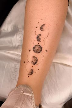 a person with a tattoo on their leg that has phases of the moon and stars