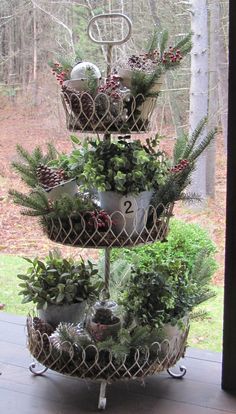 three tiered planter with evergreens and pine cones