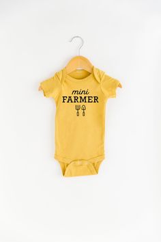 Grab this onesie for your mini farmer! Product Info See size chart in product images for more details. Measurements can vary up to 1 inch depending on color, material, etc. Cream and Mustard: 100% Cotton Mauve and Heather Olive: 25% soft airlume cotton, 25% rayon, 50% polyester Apparel Care Instructions Wash in cold water with a natural detergent. Air dry or turn inside out and dry on low. Shipping Info Orders ship out from our fulfillment center in South Dakota within 3-5 business days via USPS Slow Flower, Natural Detergent, Gardening Apron, Bees Knees, Fall Kids, Long Sleeve Onesie, Adulting Shirts, Baby Needs, Kid Tees