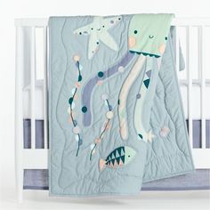 a crib bed with an ocean themed blanket