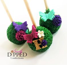 two cake pops decorated with green grass and purple flowers