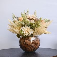 a vase filled with lots of flowers on top of a table