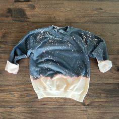 a blue and white sweatshirt with stars on it sitting on top of a wooden floor