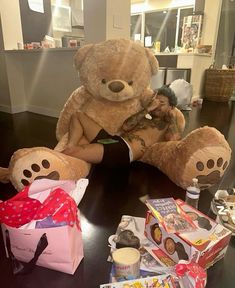 two large teddy bears sitting next to each other on a table with food and candy