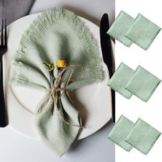 a plate with napkins and flowers on it next to forks and spoons that have been folded down