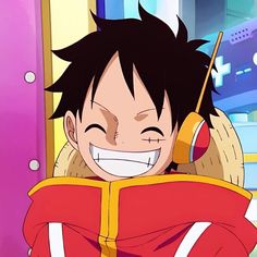 an anime character with black hair smiling and holding a cell phone to his ear while wearing a red hoodie