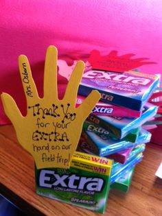 a hand made out of candy sitting on top of a desk next to a pile of books