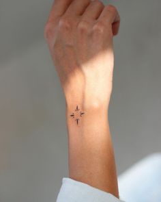 a woman's wrist with a small star tattoo on the left side of her arm