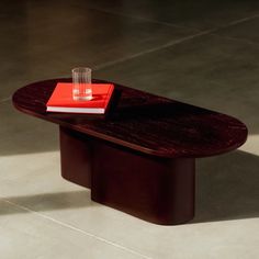 a table with a red book on it and a glass sitting on top of it