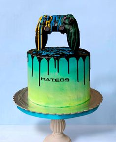 a cake with a video game controller painted on it's side and drips