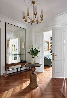 a living room filled with furniture and a large mirror on the wall next to a table