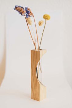 a wooden vase with dried flowers in it