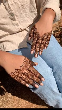 a woman's hands with hennap on her hand and the bottom half of her arm