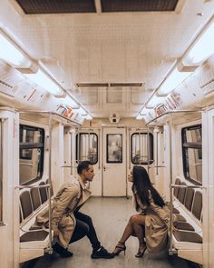 a man and woman sitting on a subway car