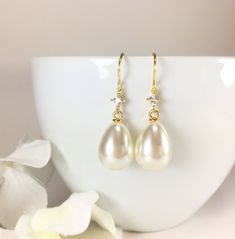 "Pearl Earrings, Gold Pearl Earrings, Simple Pearl Earrings, Pearl Dangle Earrings, Long Dangle Earrings, Minimal Earrings, Pearl Teardrop Earrings, CZ Pearl Earrings, Wedding Bridal Earrings, Bridesmaid Gift, Pearl Jewelry, Gift for Her Minimal classic design, these lovely earrings are composed of a large 21x13mm faux teardrop pearl dangling from a small diamond shaped CZ accent stone and simply hung from gold plated ear wires. Dangle length is 1-1/2\" (40mm) from the top of ear wire. Discount Classic Gold Teardrop Bridal Earrings, Classic White Teardrop Earrings For Wedding, Pear-shaped Teardrop Earrings With Pearl Drop For Anniversary, Classic Pearl Drop Crystal Earrings For Wedding, Elegant Teardrop Pendant Earrings For Wedding, Teardrop Pearl Drop Wedding Earrings, Elegant Bridal Teardrop Pendant Earrings For Wedding, Delicate Gold Teardrop Earrings For Wedding, Teardrop Pearl Drop Bridal Earrings For Anniversary