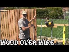 a man standing in front of a fence