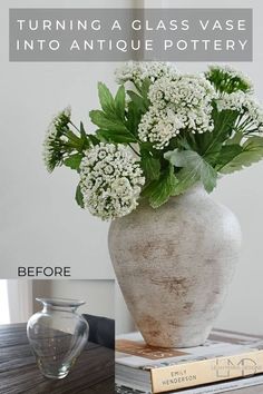 a vase filled with white flowers sitting on top of a table next to a book