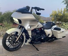 a white motorcycle parked on top of a brick road