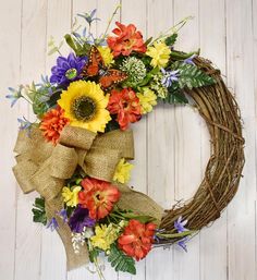 a wreath with sunflowers, daisies and other flowers