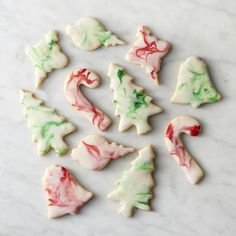 christmas cookies decorated with icing and candy canes on a marble countertop, top view