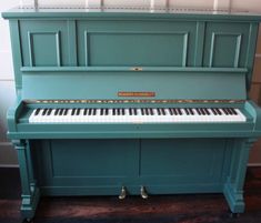 an old blue piano is sitting on the floor