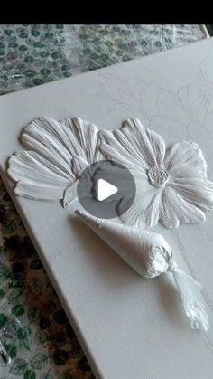 a piece of paper is being made to look like a flower on a sheet of white paper