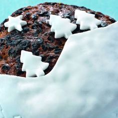 a cake with white frosting and stars on it's icing, sitting on a blue surface