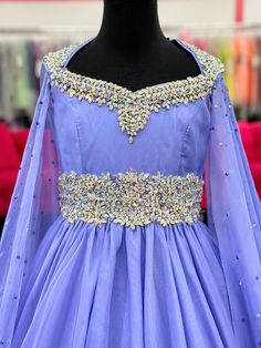 The Samantha Blake 1023 Girls Long Cape Sleeve Pageant Dress is perfect for any special occasion. The crystal cut out back and A line silhouette add a touch of elegance to the chiffon material. With long cape sleeves flowing from a cap sleeve, your child will feel like a true princess in this beautiful dress. Perfect Unique look for Pageants! Sizes: 2-16 Colors: Periwinkle Elegant Purple Pageant Dress, Organza Evening Dress With Fitted Bodice For Pageants, Purple Embellished Pageant Dress, Purple Embellished Dress For Pageant, Elegant Organza Gown For Pageants, Embellished Organza Pageant Dress, Party Gown With Fitted Bodice In Georgette, Crystal-embellished Fitted Bodice Evening Dress For Pageant, Sheer Bodice Floor-length Dress For Pageants