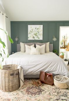 a white bed sitting in a bedroom next to a basket on top of a rug