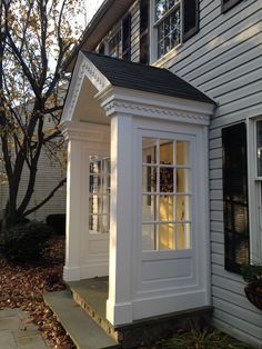 a small white house sitting next to a tree