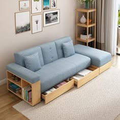 a blue couch sitting on top of a hard wood floor next to a book shelf