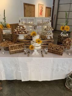 a table with sunflowers and desserts on it at a wedding or other function