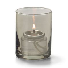 a small glass candle holder with a lit candle in it