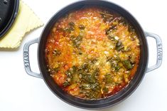 a pot filled with food sitting on top of a white counter next to a yellow cloth