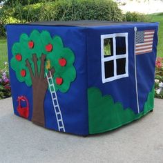 a child's play tent with an apple tree and ladder painted on the side