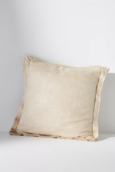 a white pillow sitting on top of a bed