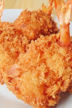 some fried food on a white plate with shrimp sticks sticking out of the top of it