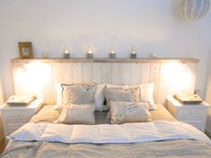 a bed with two lamps on either side of the headboard and one night stand