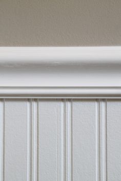 the corner of a wall with white paint on it's trim and molding